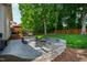 Expansive backyard with a patio, fire pit, seating, and mature trees at 10113 San Remo Pl, Wake Forest, NC 27587