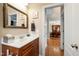 Charming powder room with cherry vanity and decorative mirror, providing an elegant view of the dining area at 10113 San Remo Pl, Wake Forest, NC 27587