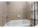 Bright bathroom featuring neutral tile shower and tub with modern fixtures and a gray and white shower curtain at 10113 San Remo Pl, Wake Forest, NC 27587