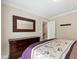 Comfortable bedroom featuring neutral walls, plush carpet, and a chest of drawers with a decorative mirror at 10113 San Remo Pl, Wake Forest, NC 27587