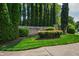 Elegant entrance to Porto Fino neighborhood featuring lush greenery and manicured shrubs at 10113 San Remo Pl, Wake Forest, NC 27587