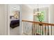 Bright hallway with decorative chandelier, wood railing, and view into a bedroom at 10113 San Remo Pl, Wake Forest, NC 27587