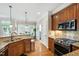 Open kitchen layout with a breakfast nook features stainless steel appliances, granite countertops, and wood floors at 10113 San Remo Pl, Wake Forest, NC 27587
