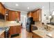 Spacious kitchen offers stainless steel appliances, granite countertops, and custom wood cabinetry with hardwood floors at 10113 San Remo Pl, Wake Forest, NC 27587