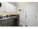 Well-equipped laundry room featuring modern washer and dryer units, ample storage space, and tiled floors at 10113 San Remo Pl, Wake Forest, NC 27587