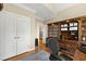 Spacious home office featuring hardwood floors and built-in shelving, and a large window offering backyard views at 10113 San Remo Pl, Wake Forest, NC 27587