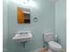 Bathroom featuring blue walls, a white toilet and sink, and a mirror at 1024 Chalmers St, Durham, NC 27707