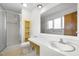 Bathroom with a glass shower door, toilet, large mirror, and sink at 1024 Chalmers St, Durham, NC 27707