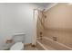 Bathroom featuring a toilet and tub/shower combo with beige tile at 1024 Chalmers St, Durham, NC 27707