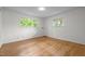 Bedroom with hardwood flooring, two windows, and white walls at 1024 Chalmers St, Durham, NC 27707
