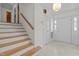 Bright foyer with wooden stairs, white walls, and white tile flooring at 1024 Chalmers St, Durham, NC 27707