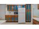 Kitchen showing wood cabinets with blue panels, a built-in microwave, and a full-size white refrigerator at 1024 Chalmers St, Durham, NC 27707