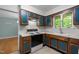 Updated kitchen showcasing wood cabinetry with striking blue accents, plus modern appliances and ample counter space at 1024 Chalmers St, Durham, NC 27707