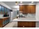 View of an open kitchen with wood cabinetry, blue panel accents, a breakfast bar, and modern appliances at 1024 Chalmers St, Durham, NC 27707
