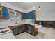 Open kitchen featuring wood cabinets with vibrant blue panels, a functional layout, and bright natural light at 1024 Chalmers St, Durham, NC 27707