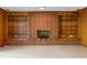 Living room highlighting a brick fireplace with built-in shelving and wood paneling, adding character to the space at 1024 Chalmers St, Durham, NC 27707