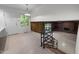 Open-concept living area with staircase and railing, leading to living room with brick fireplace and shelving at 1024 Chalmers St, Durham, NC 27707