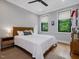 Cozy bedroom featuring wood floors, a bed, and bright windows with natural light at 1027 S Duke St, Durham, NC 27707