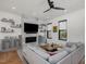 Bright living room with a fireplace, a large TV, a ceiling fan, and hardwood floors at 1027 S Duke St, Durham, NC 27707