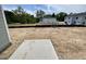 An unfinished backyard featuring an area of cement with newly constructed homes in the background at 1029 Mountain Crown St, Durham, NC 27703