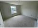 An unfinished bedroom is freshly painted white with electrical connection points and a large single hung window at 1029 Mountain Crown St, Durham, NC 27703