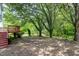 Overgrown backyard featuring mature trees with a rustic swing set at 103 Trent Woods Way, Cary, NC 27519