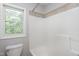 Bathroom with a tile-lined shower and bath combination beneath a window at 103 Trent Woods Way, Cary, NC 27519