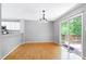 Open dining area boasts sliding door to outdoor deck and view into the modern kitchen at 103 Trent Woods Way, Cary, NC 27519