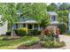 Charming blue two-story home with a lush front yard and a beautiful flower garden at 103 Trent Woods Way, Cary, NC 27519