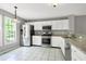 Modern kitchen features white cabinets, stainless steel appliances, granite counters and tile floors at 103 Trent Woods Way, Cary, NC 27519