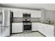 Modern kitchen features white cabinets, granite countertops, and stainless steel appliances at 103 Trent Woods Way, Cary, NC 27519