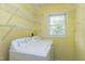 Bright laundry room with white washer and dryer, white shelving, and natural light from window at 103 Trent Woods Way, Cary, NC 27519