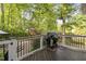 Outdoor deck area with grill, overlooking a green backyard with lush foliage at 105 Bergeron Way, Cary, NC 27519