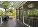 An outdoor deck offers a view into a screened porch with wooded backyard in the background at 105 Bergeron Way, Cary, NC 27519