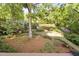 Picturesque view of the backyard, showcasing a pond with fountain, mature trees, and lush landscaping at 105 Bergeron Way, Cary, NC 27519