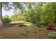 The landscaped backyard features a tranquil pond with a fountain, framed by mature trees and colorful plantings at 105 Bergeron Way, Cary, NC 27519
