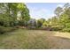 Spacious backyard with a wooden fence, providing privacy and a view of the neighborhood pond at 105 Bergeron Way, Cary, NC 27519