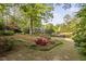 Expansive landscaped yard features mature trees, shrubs, colorful flowers, and a pond with a fountain at 105 Bergeron Way, Cary, NC 27519
