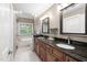 Bathroom featuring double sinks with granite counters and a soaking tub by the window at 105 Bergeron Way, Cary, NC 27519