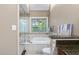 Bright bathroom featuring a soaking tub with tile surround and a window with wooded views at 105 Bergeron Way, Cary, NC 27519