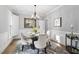 Elegant dining room with modern chandelier, seating for six, and views of the backyard at 105 Bergeron Way, Cary, NC 27519