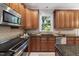 The kitchen boasts dark cabinets, stainless steel appliances, granite counters, and natural light from the window at 105 Bergeron Way, Cary, NC 27519