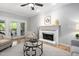 Comfortable living room with fireplace, ceiling fan and easy access to an outdoor screened in deck at 105 Bergeron Way, Cary, NC 27519