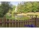 View of the pond with fountain feature and backyard foliage, from behind a wood fence and floral border at 105 Bergeron Way, Cary, NC 27519