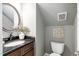 A quaint powder room featuring a dark vanity with a round mirror, adding character to the interior decor at 105 Bergeron Way, Cary, NC 27519
