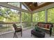 Relaxing screened porch with wicker furniture, rug, ceiling fan and views of the wooded surroundings at 105 Bergeron Way, Cary, NC 27519