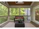 The screened in porch features wicker furniture, natural light, wood ceiling, and private wooded backyard at 105 Bergeron Way, Cary, NC 27519