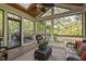 Inviting screened porch with a ceiling fan, skylights, and wooded scenery, creating a tranquil space at 105 Bergeron Way, Cary, NC 27519