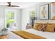 Bright bedroom with neutral decor, ceiling fan, and windows showcasing a lush outdoor view at 107 E Hammond St, Durham, NC 27704