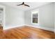 Empty bedroom with hardwood floors, ceiling fan, and a large window at 107 E Hammond St, Durham, NC 27704